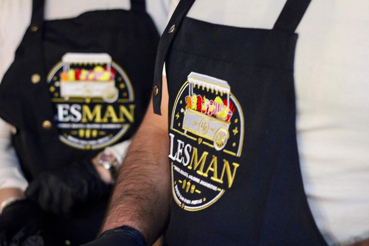 Detalle del logo LESMAN bordado en el delantal del staff