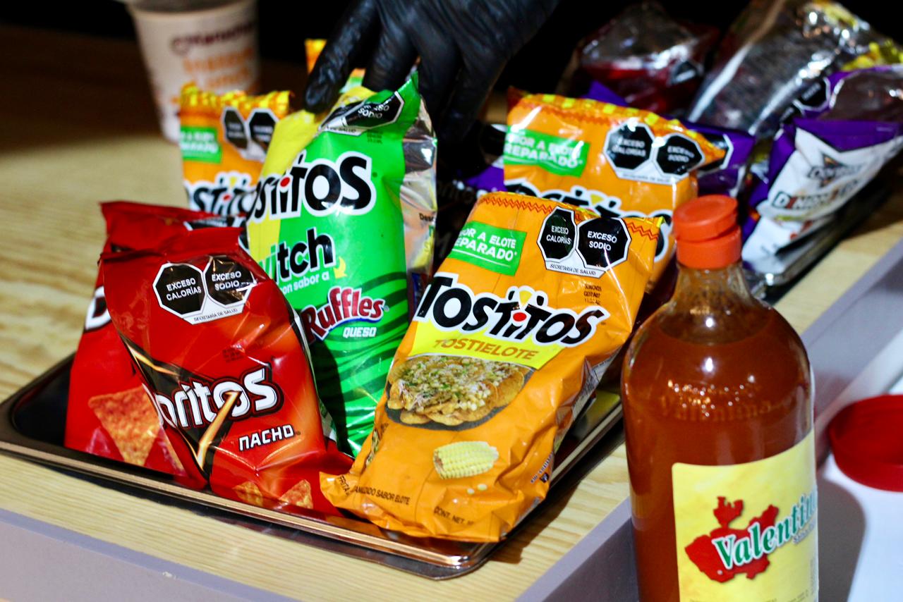 Variedad de botanas de bolsa y salsa Valentina